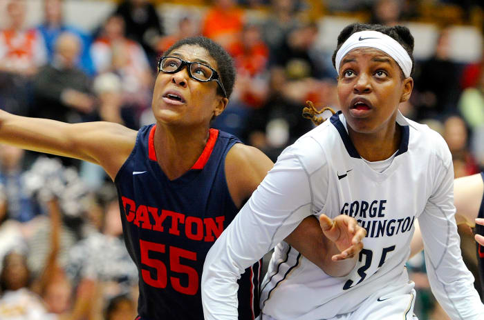 Jonquel Jones in a George Washington jersey alongside a Dayton opponent